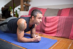 Person performing a controlled core exercise on a mat while maintaining a neutral spine